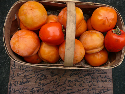 A basket of Oriental persimmons atop the signed walnut cutting board given to me at the SEOPA conference.